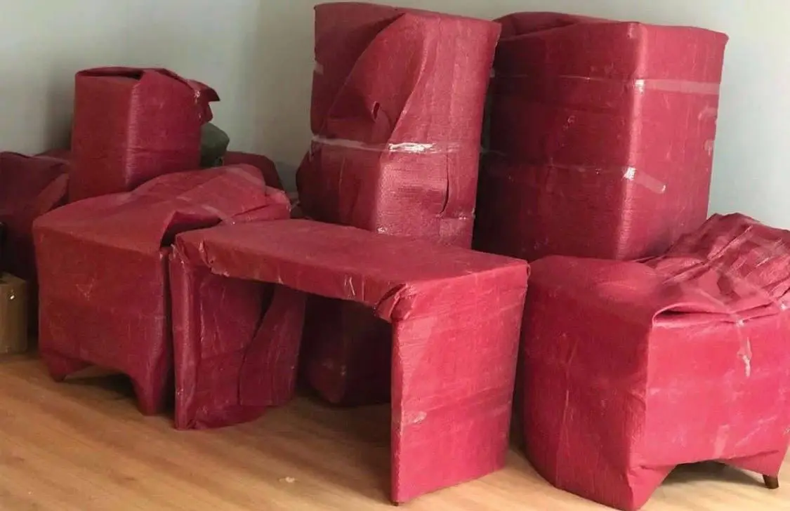 Beylikdüzü nakliyat: kırmızı koruyucuyla paketlenmiş masa ve koltuklar